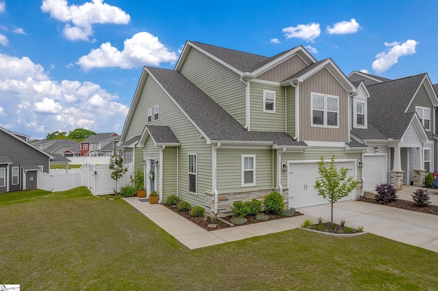 view of front facade with concrete driveway, an attached garage, fence, and a front yard