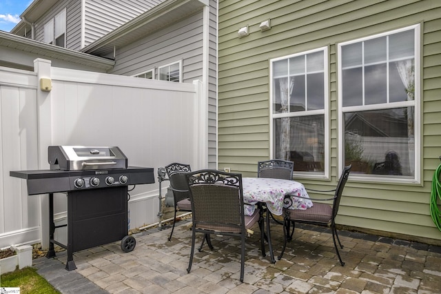 view of patio with grilling area, fence, and outdoor dining space