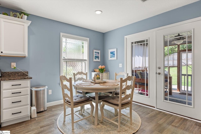 dining room featuring plenty of natural light, light wood-style flooring, baseboards, and french doors