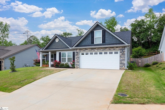 craftsman house featuring concrete driveway, stone siding, fence, and a front yard