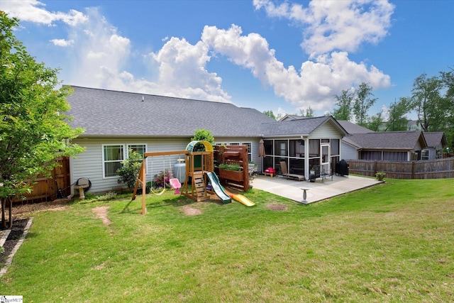 rear view of house with a yard, a playground, a fenced backyard, and a sunroom