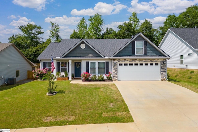 craftsman inspired home with roof with shingles, cooling unit, driveway, and a front lawn