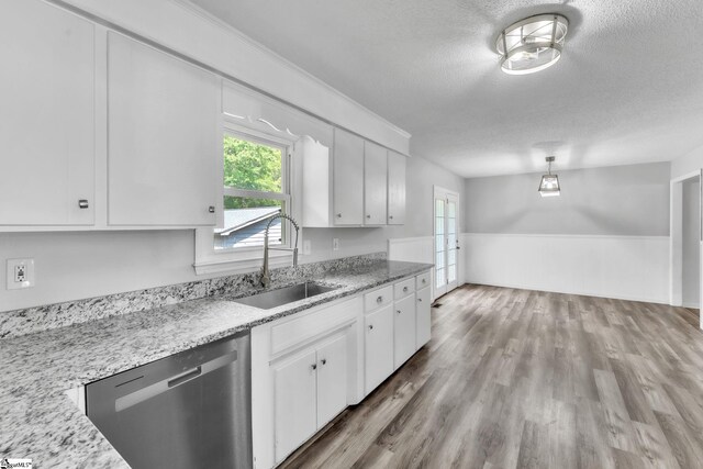 kitchen featuring a sink, a textured ceiling, dishwasher, and white cabinets