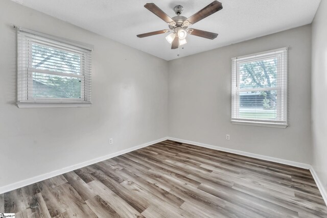 empty room featuring baseboards, a ceiling fan, and wood finished floors