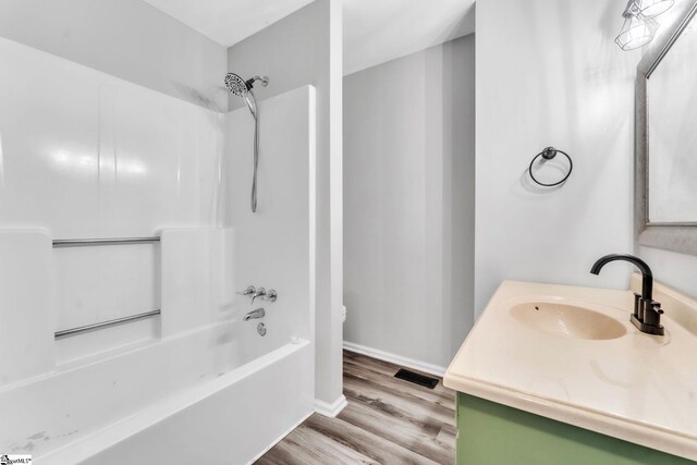full bath featuring visible vents, vanity, wood finished floors, toilet, and bathing tub / shower combination