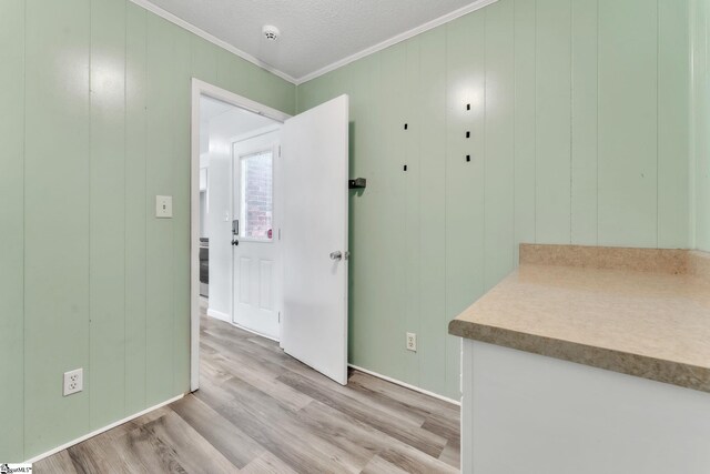 unfurnished room featuring crown molding and light wood-style floors