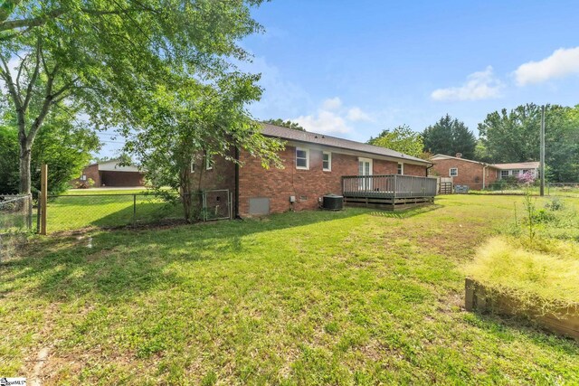 view of yard featuring a fenced backyard, central air condition unit, and a deck