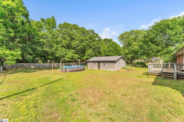 view of yard featuring a fenced backyard, a fenced in pool, and a wooden deck