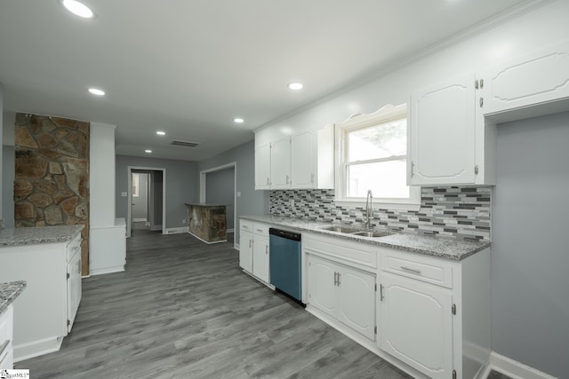 kitchen featuring white cabinets, baseboards, a sink, and dishwasher