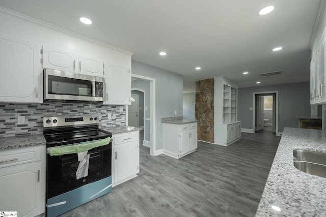 kitchen with white cabinets, stainless steel appliances, baseboards, and visible vents