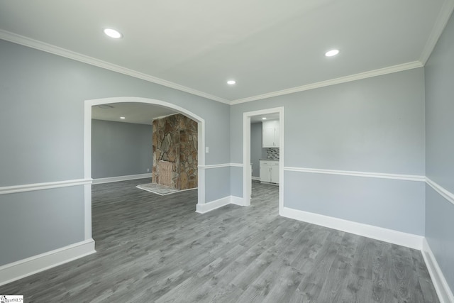 spare room with arched walkways, baseboards, recessed lighting, and wood finished floors