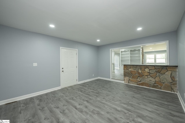 spare room with baseboards, recessed lighting, wood finished floors, and visible vents