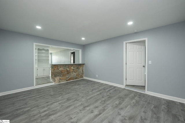 unfurnished living room featuring baseboards, recessed lighting, and wood finished floors
