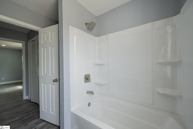 bathroom with shower / bath combination, baseboards, and wood finished floors