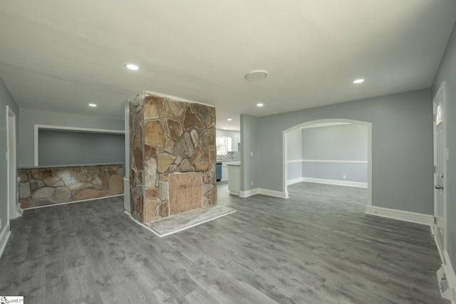 interior space with arched walkways, baseboards, recessed lighting, and wood finished floors