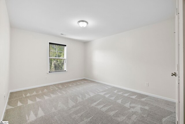 carpeted empty room with baseboards