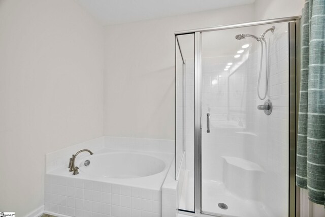full bath featuring a shower stall and a garden tub
