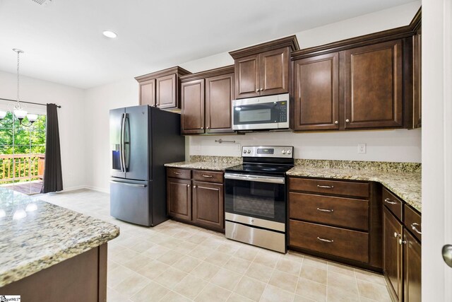 kitchen featuring dark brown cabinets, light stone countertops, a notable chandelier, appliances with stainless steel finishes, and decorative light fixtures