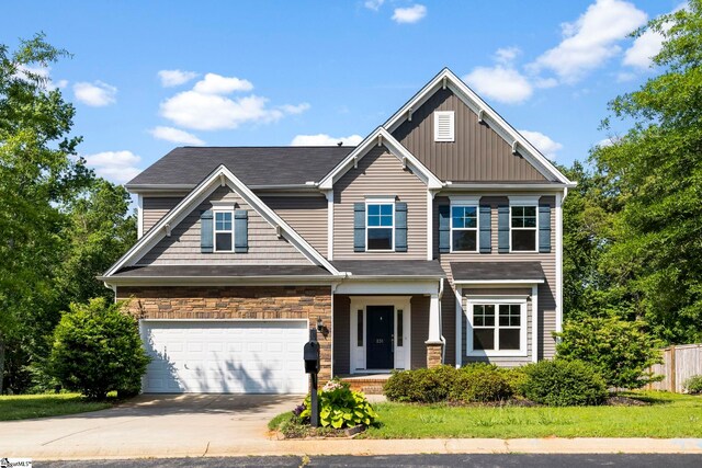 craftsman-style house with fence, board and batten siding, an attached garage, and concrete driveway