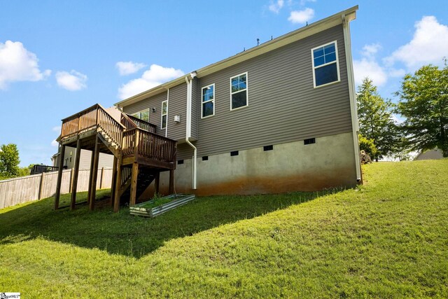 back of property featuring fence, a wooden deck, stairway, crawl space, and a yard