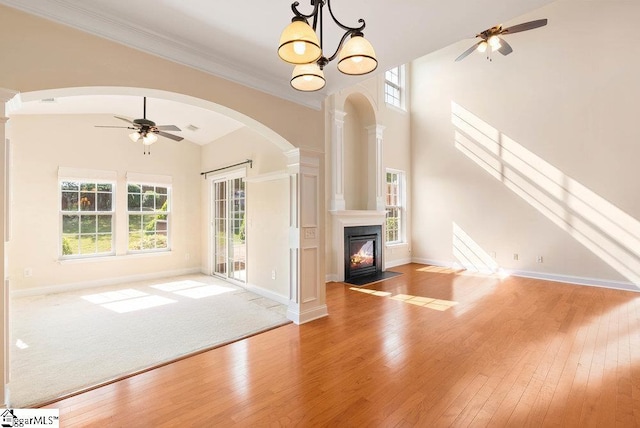 unfurnished living room featuring wood-type flooring, a ceiling fan, and high vaulted ceiling