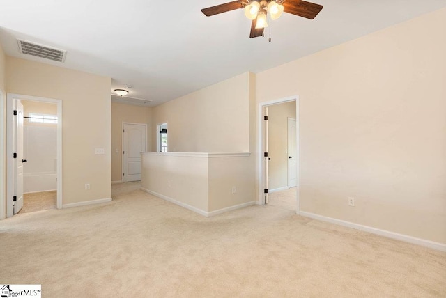 unfurnished room with light colored carpet, ceiling fan, visible vents, and baseboards