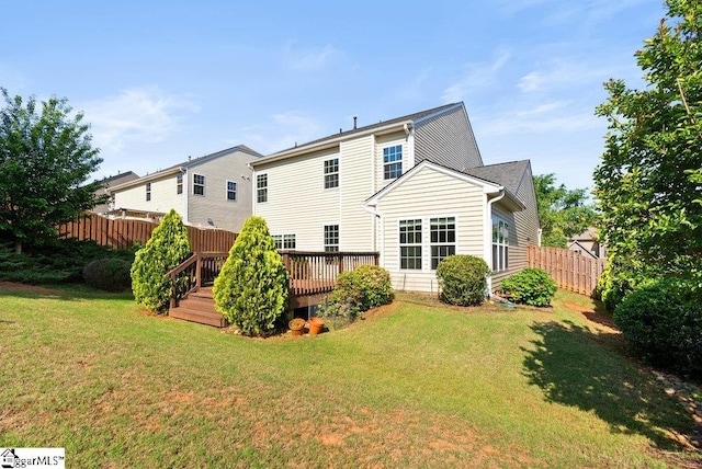 back of house featuring fence, a wooden deck, and a yard