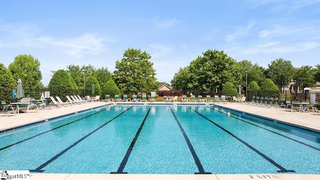 community pool with a patio and fence