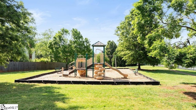 community jungle gym featuring fence and a yard