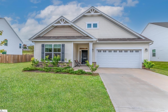 craftsman house with a garage, fence, driveway, and a front lawn