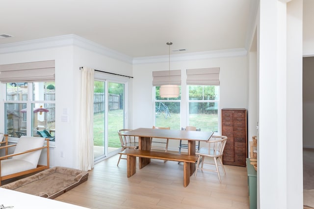 dining room with crown molding, visible vents, and light wood-type flooring