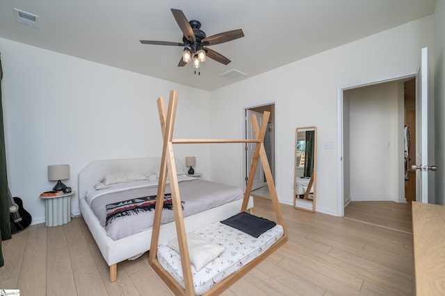 bedroom featuring baseboards, a ceiling fan, light wood-style flooring, and visible vents