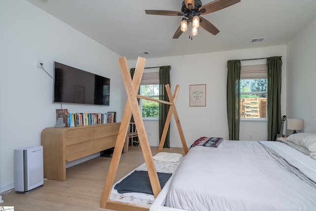 bedroom with multiple windows, light wood-style flooring, and visible vents