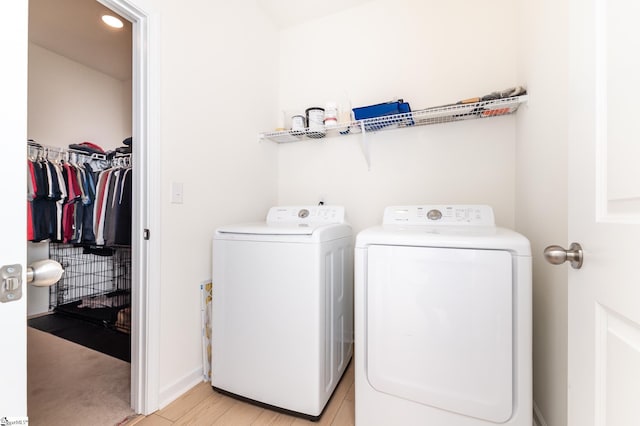washroom with light wood-style floors, separate washer and dryer, and laundry area