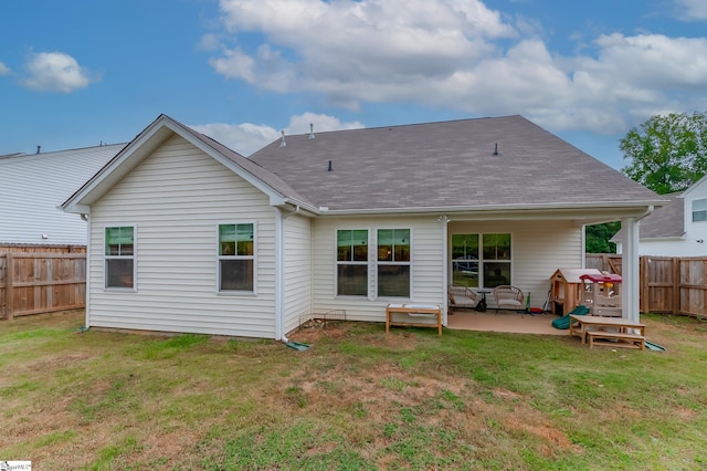 rear view of house with roof with shingles, a patio area, a fenced backyard, an outdoor hangout area, and a yard
