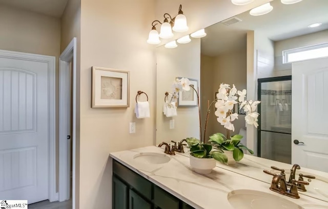 bathroom featuring a sink, a shower stall, double vanity, and visible vents