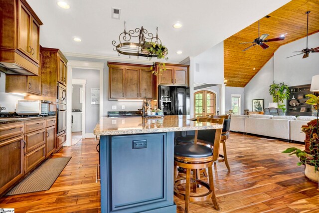 129 Eliza Ln, Marietta, SC 29661 - kitchen with visible vents, an island with sink, ceiling fan, light wood finished floors, and appliances with stainless steel finishes