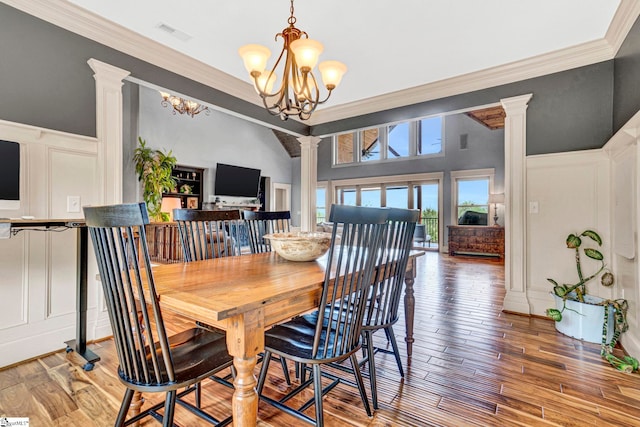dining room with an inviting chandelier, a decorative wall, ornate columns, visible vents, and ornamental molding