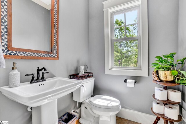 bathroom with a sink, baseboards, and toilet