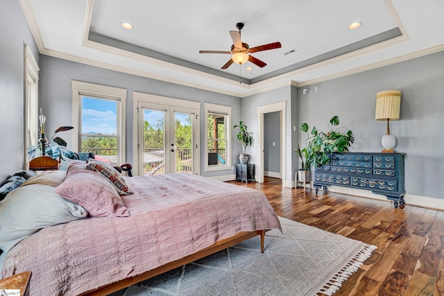 bedroom featuring a raised ceiling, access to exterior, french doors, recessed lighting, and wood finished floors