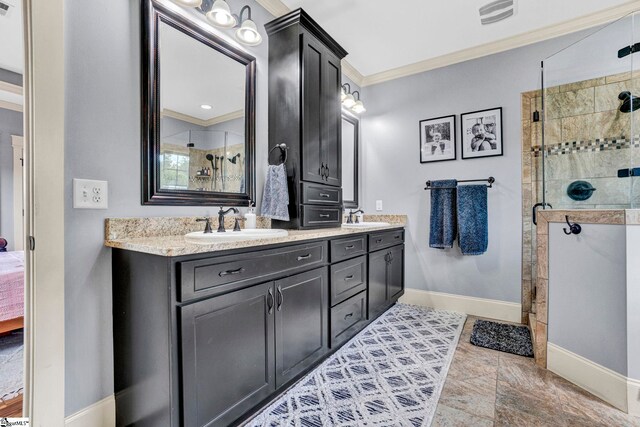 bathroom featuring a sink, baseboards, visible vents, ornamental molding, and a stall shower