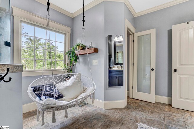 bathroom with baseboards, stone finish flooring, crown molding, and vanity