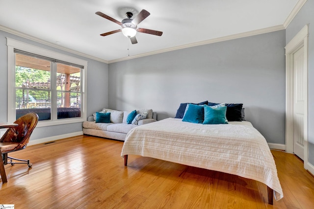 bedroom featuring light wood-style floors, baseboards, ornamental molding, and a ceiling fan