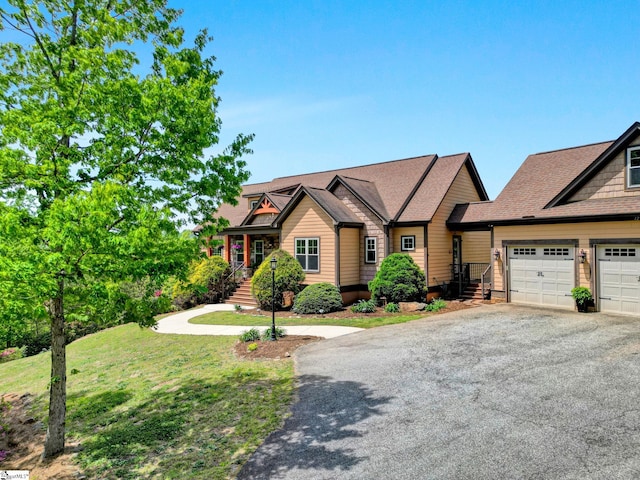 view of front of property with a garage, a shingled roof, aphalt driveway, and a front yard