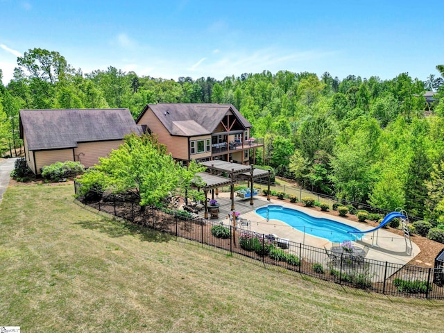 view of pool with a lawn, a patio area, fence, a fenced in pool, and a water slide