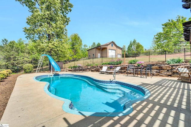 view of swimming pool featuring a fenced in pool, fence, a water slide, and a patio area