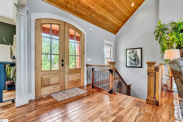 entryway with wooden ceiling, arched walkways, plenty of natural light, and wood finished floors