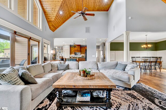 129 Eliza Ln, Marietta, SC 29661 - living area with visible vents, high vaulted ceiling, ceiling fan with notable chandelier, light wood-style floors, and ornate columns