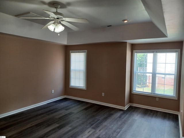 empty room featuring dark wood finished floors, baseboards, and ceiling fan