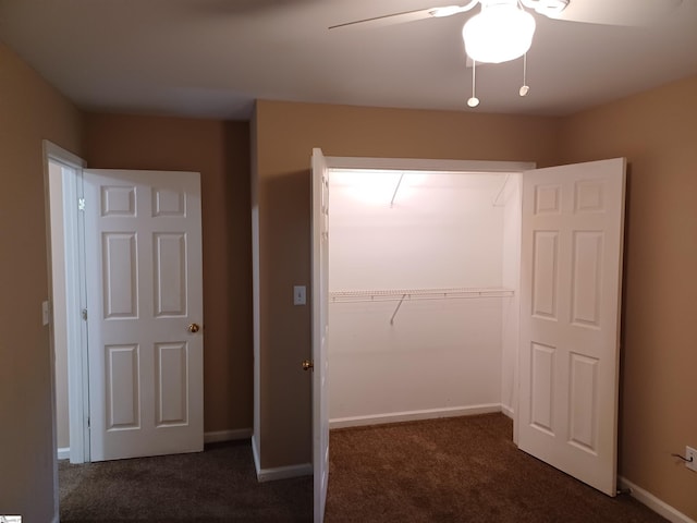 unfurnished bedroom featuring dark colored carpet, a closet, a ceiling fan, and baseboards